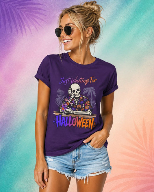 Funny Halloween shirt for women featuring a skeleton drinking a cocktail with “Just Waiting for Halloween” text on a purple Summerween aesthetic tee