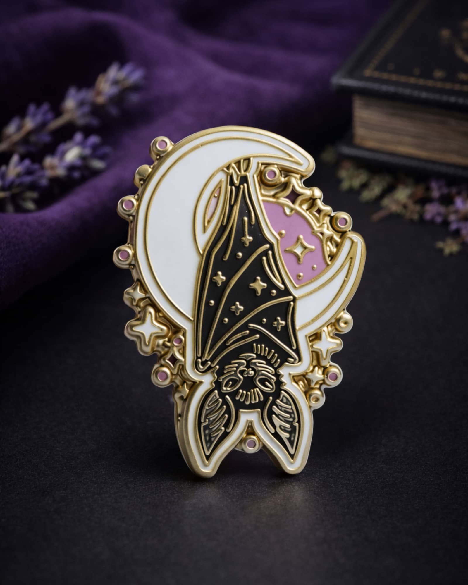 Decorative brooch with celestial design on a dark surface
