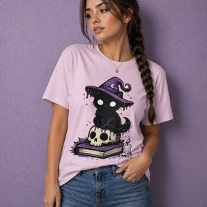 Woman wearing pink witchy t shirt with cute witch shirt design featuring black cat on skull and book