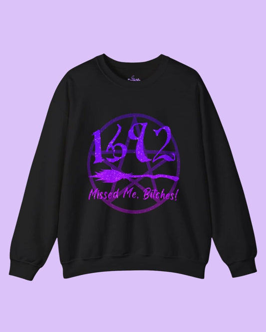 Flat lay of the black Missed Me Bitches sweatshirt showcasing the bold statement graphic on a dark background, highlighting the cozy fabric.