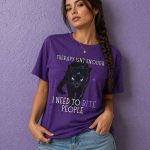 Woman wearing a purple witchy t shirt with black cat design and funny gothic quote “therapy isn’t enough I need to bite people”