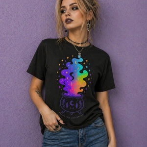 Woman wearing black witchy t shirt with colorful cauldron design in witch aesthetic clothing style