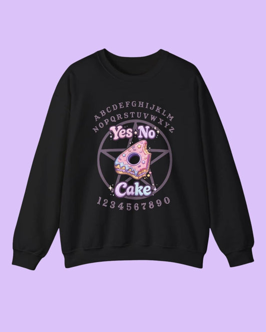 Flat lay of the Yes No Cake sweatshirt showcasing the bold witchy humor graphic on a dark background, highlighting the cozy fabric and design details.