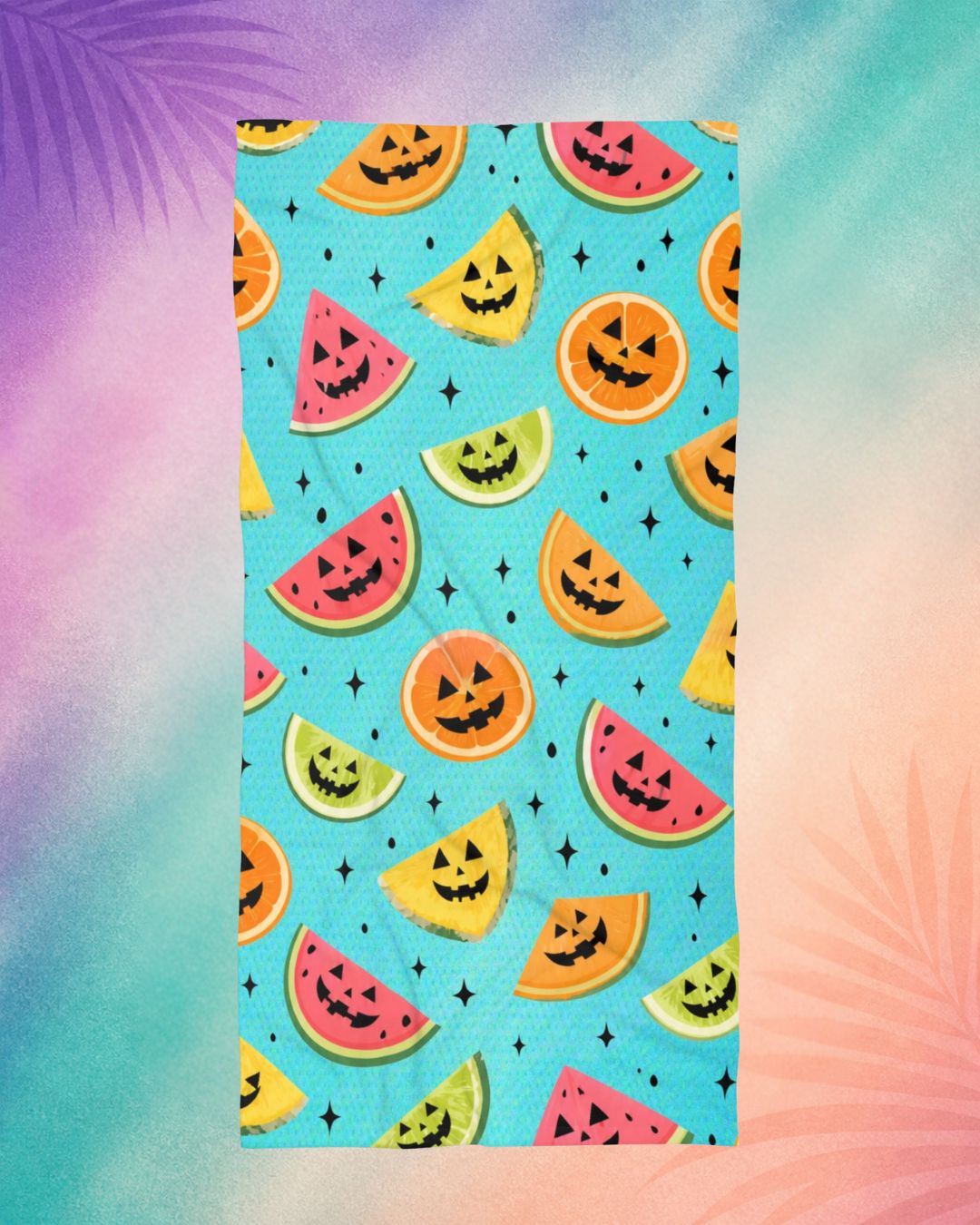 Summerween aesthetic beach towel with fruit jack o lantern pattern including watermelon, citrus, and pineapple, spooky summer vibe