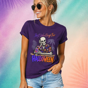 Funny Halloween shirt for women featuring a skeleton drinking a cocktail with “Just Waiting for Halloween” text on a purple Summerween aesthetic tee
